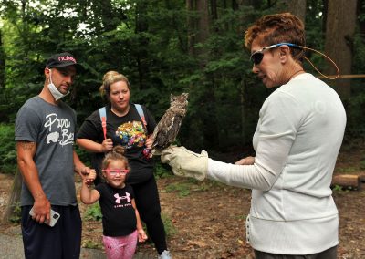 woman with an owl on her hand and visitors